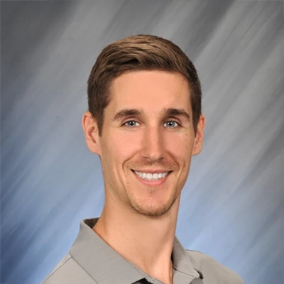 Alex Bartlinksi smiling in a grey polo.